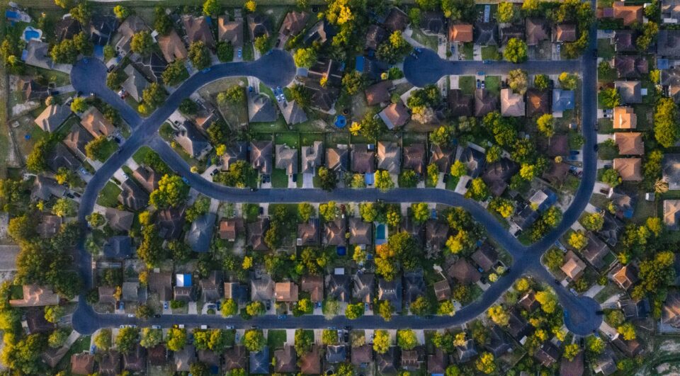 Aerial view of a flat Texas suburban neighborhood with lawns, typical of Pearland, TX