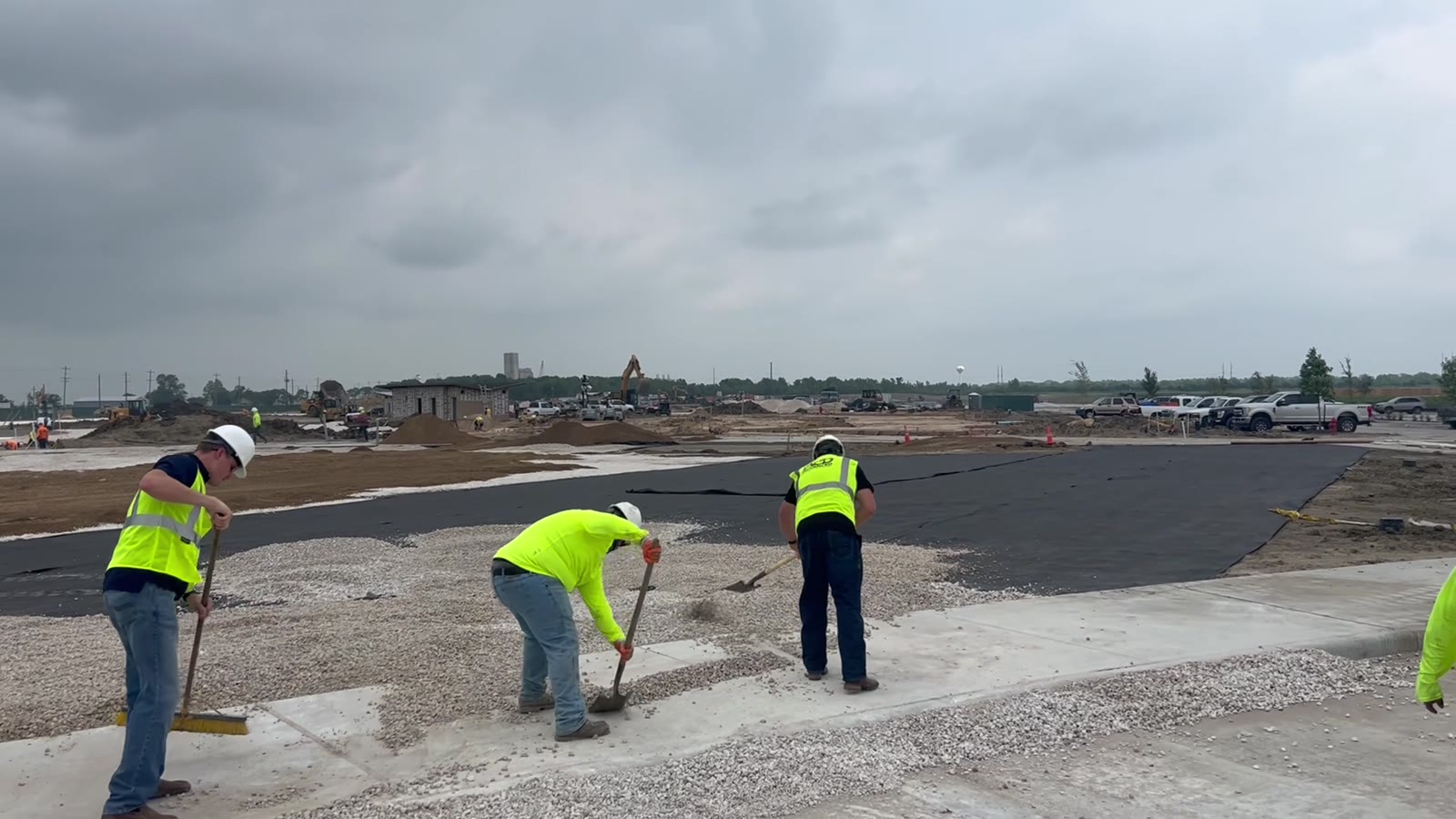 Crew spreading a compacted decomposed granite base for commercial turf in Dayton, TX