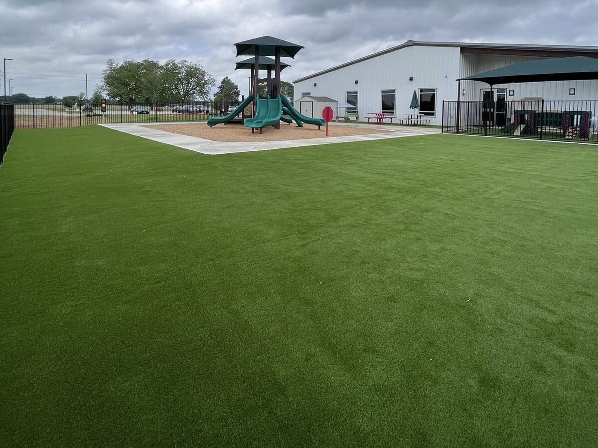 Large artificial turf lawn in front of the playground at Graceview Baptist in Tomball, TX