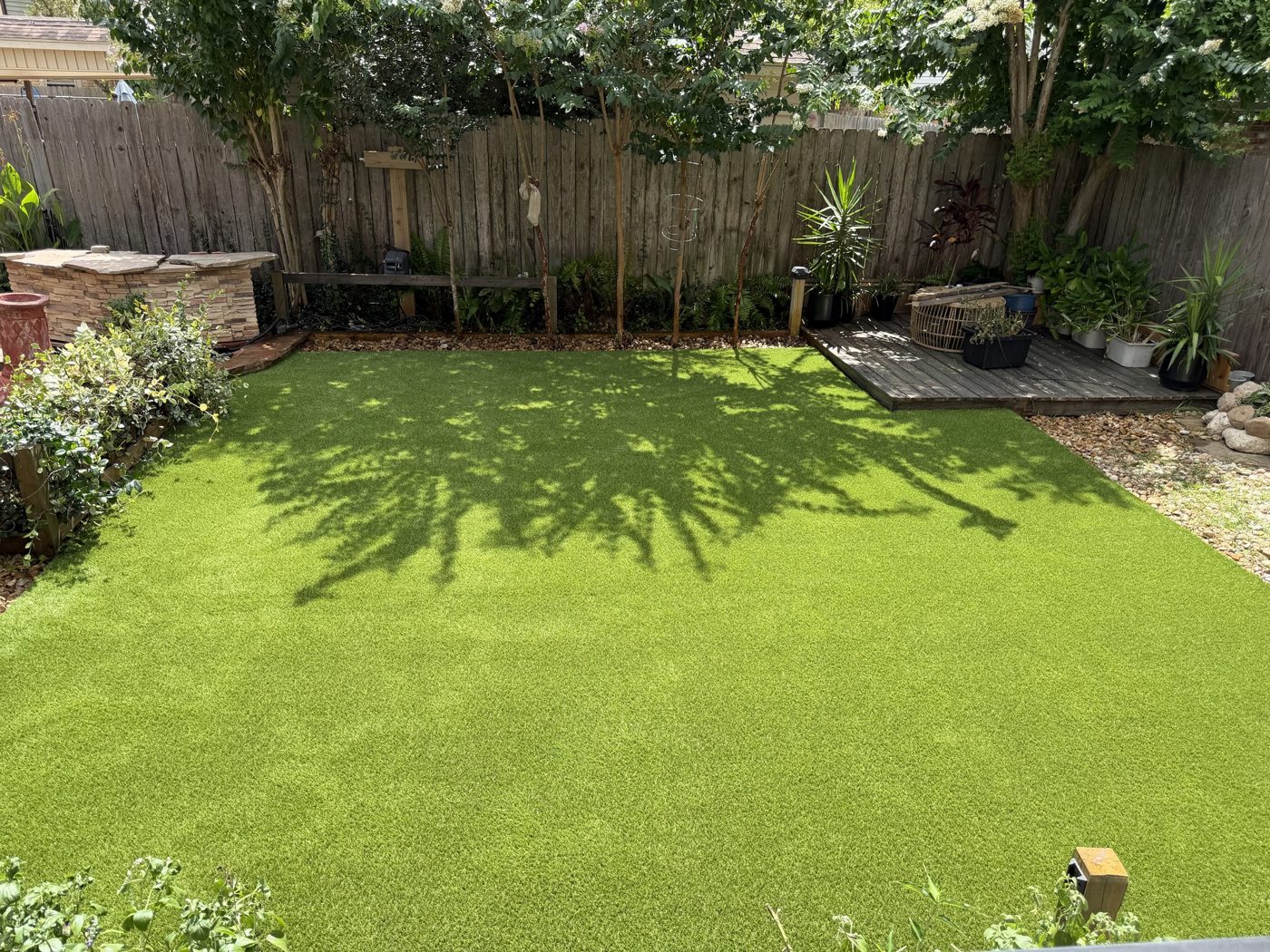Pet turf lawn next to a wood deck in a Willis, TX backyard